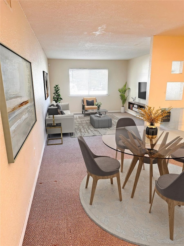 carpeted dining space featuring a textured ceiling