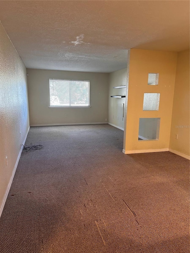 carpeted spare room featuring a textured ceiling