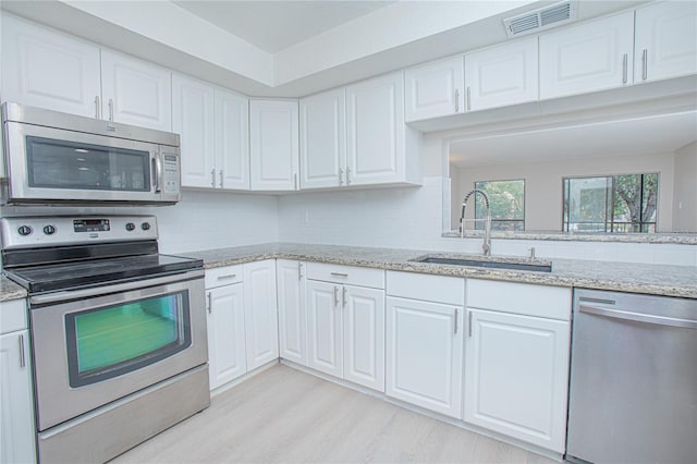 kitchen featuring light hardwood / wood-style floors, white cabinetry, sink, and appliances with stainless steel finishes