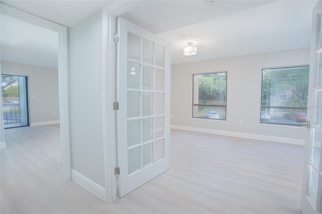 hallway with french doors and light wood-type flooring