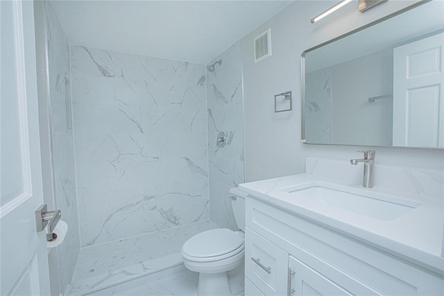 bathroom featuring vanity, toilet, and tiled shower