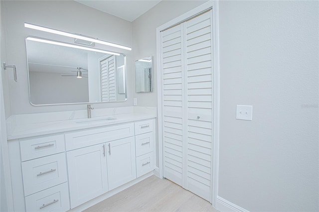 bathroom with ceiling fan, vanity, and hardwood / wood-style flooring