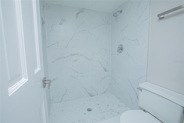 bathroom featuring toilet and a tile shower