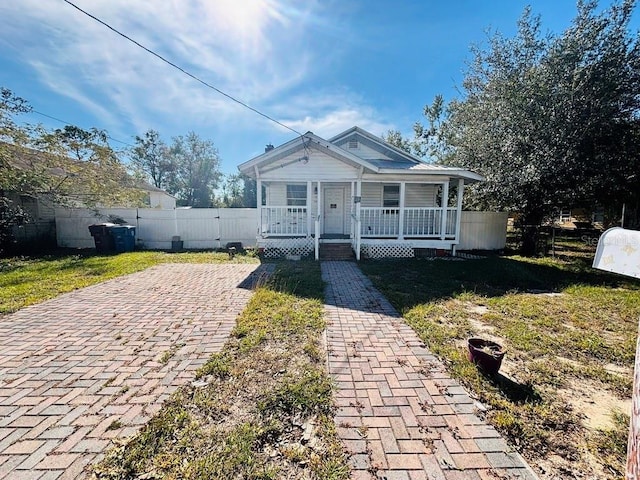 bungalow with covered porch and a front yard