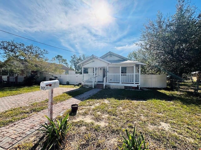 bungalow with covered porch and a front yard