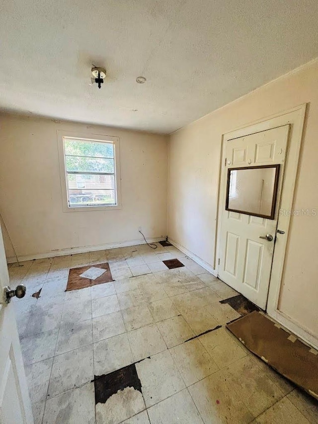 unfurnished room with a textured ceiling