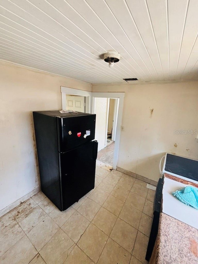 kitchen featuring range, wood ceiling, and light tile patterned flooring