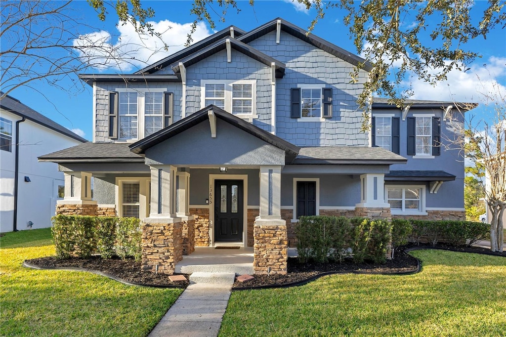 craftsman-style home with a front lawn and a porch