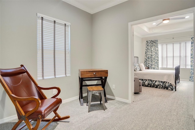 carpeted bedroom with a tray ceiling and ornamental molding