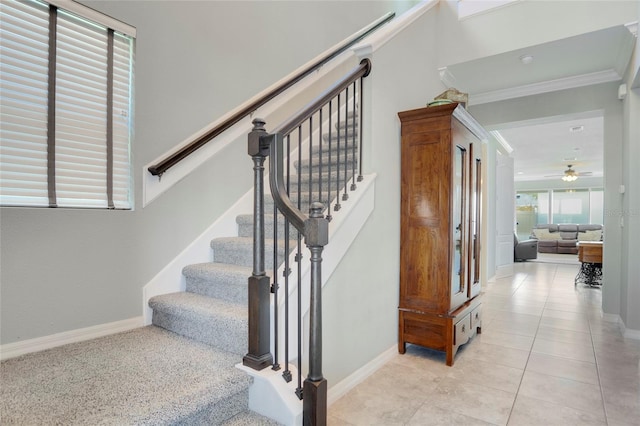 staircase with tile patterned flooring, ceiling fan, and crown molding