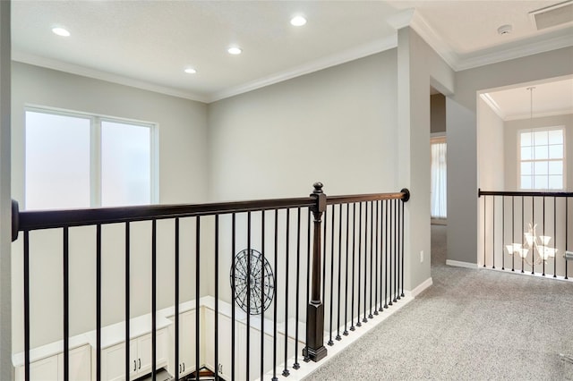 corridor featuring carpet flooring, an inviting chandelier, and ornamental molding