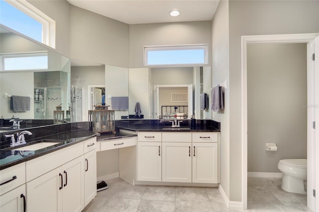 bathroom with tile patterned floors, vanity, toilet, and a shower with shower door