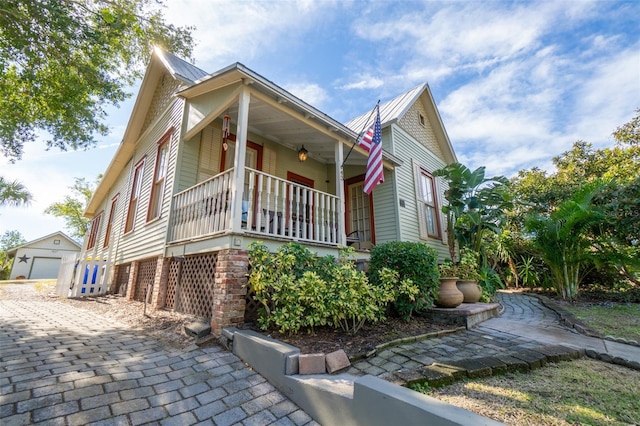 view of front of house featuring a garage, an outdoor structure, and a porch