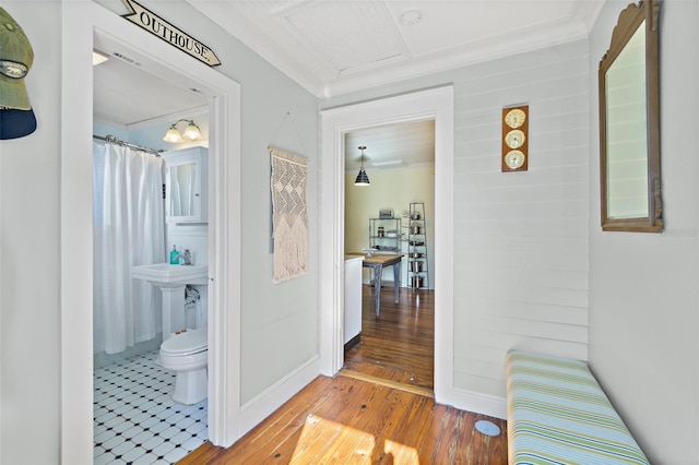 hallway featuring hardwood / wood-style floors and ornamental molding