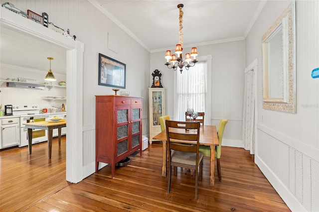 dining area with an inviting chandelier, hardwood / wood-style floors, and ornamental molding