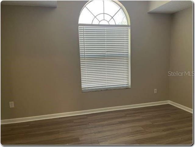 unfurnished room with dark hardwood / wood-style flooring