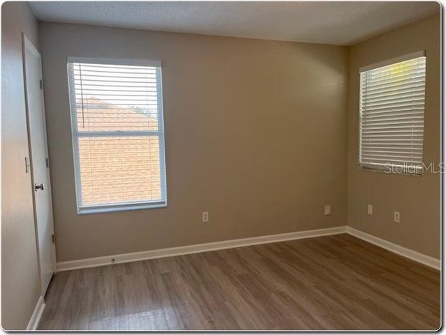 unfurnished room featuring hardwood / wood-style floors and a healthy amount of sunlight