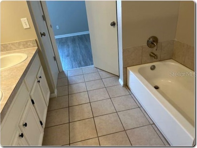 bathroom featuring a tub to relax in, tile patterned flooring, and vanity