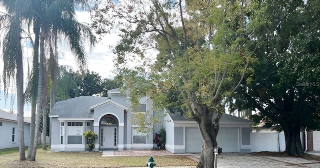 view of front of house with a garage, driveway, and stucco siding