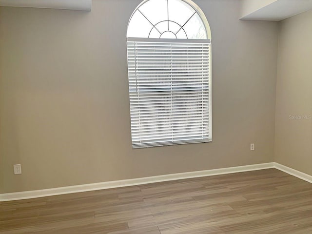 spare room featuring wood finished floors and baseboards