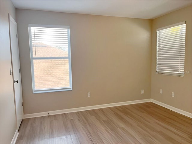 spare room with light wood-style floors and baseboards