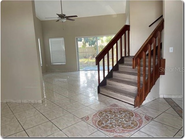 stairs with ceiling fan, baseboards, and tile patterned floors