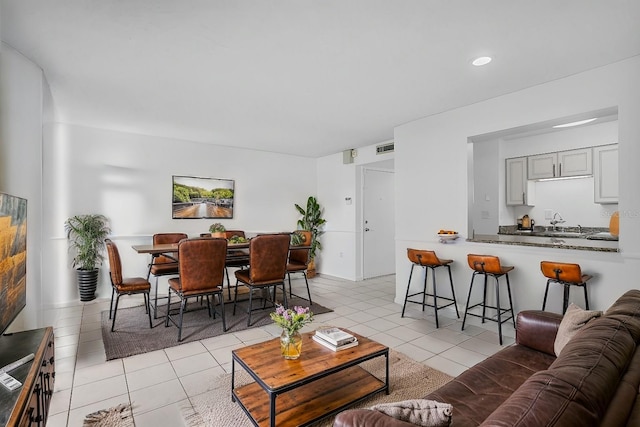 living area featuring light tile patterned flooring, visible vents, and recessed lighting