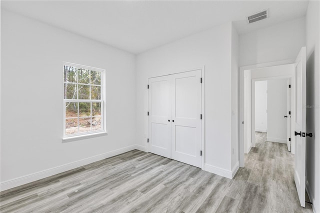 unfurnished bedroom featuring light hardwood / wood-style floors and a closet