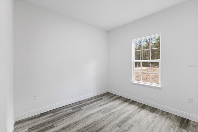 unfurnished room with hardwood / wood-style flooring