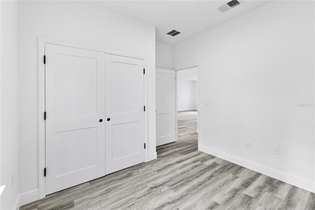 unfurnished bedroom featuring a closet and light hardwood / wood-style flooring