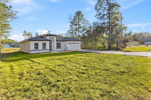 view of front of home with a front yard and a garage