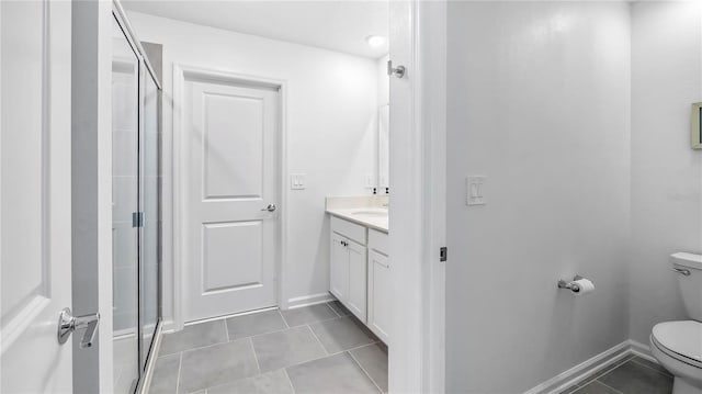 bathroom with a shower with door, tile patterned flooring, vanity, and toilet