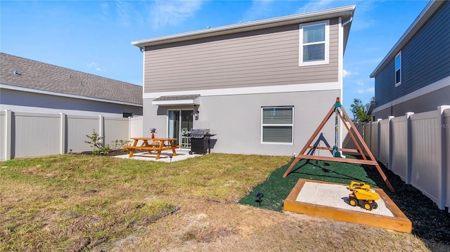 back of property with a yard and a patio