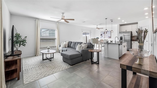 living room with ceiling fan and sink