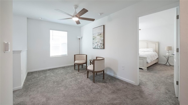 sitting room with ceiling fan and light carpet