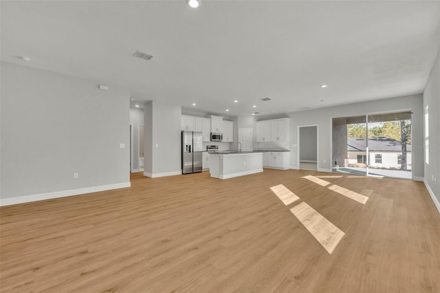 1607 W Diamond Dr, Citrus Springs, FL 34434 - unfurnished living room featuring baseboards, a sink, light wood finished floors, and recessed lighting