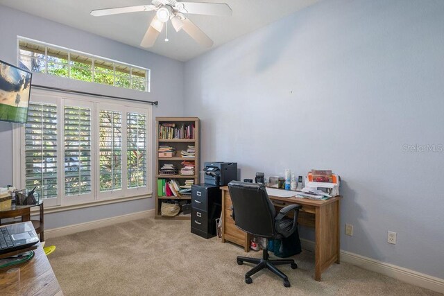 office area featuring a ceiling fan, light colored carpet, and baseboards