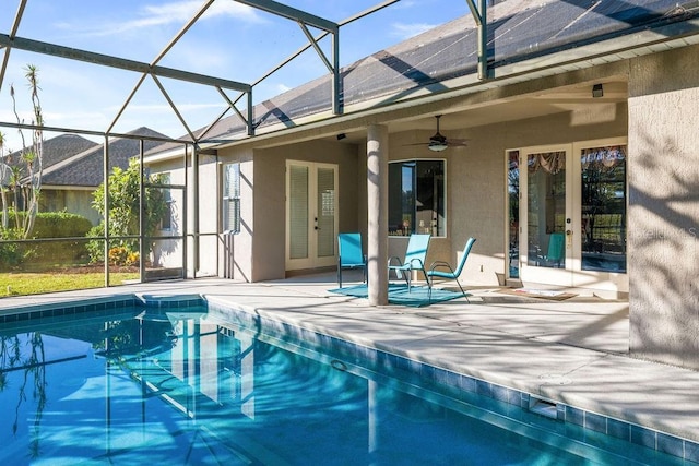 pool with ceiling fan, glass enclosure, and a patio