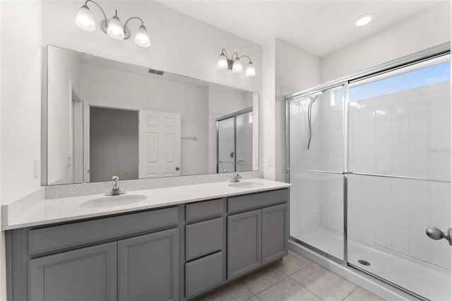 bathroom with tile patterned floors, vanity, and a shower with door