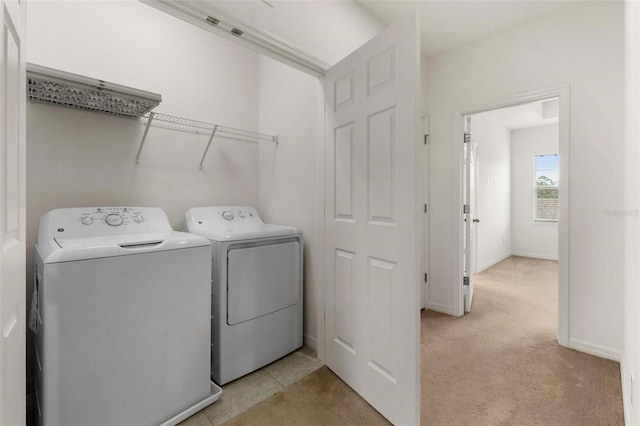 washroom featuring washer and dryer and light carpet