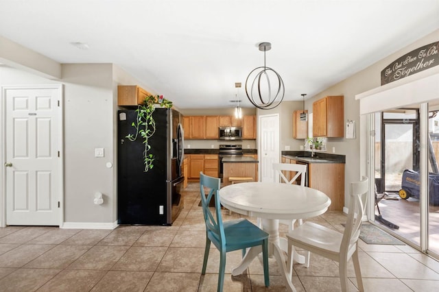 dining area featuring light tile patterned flooring, a notable chandelier, and sink