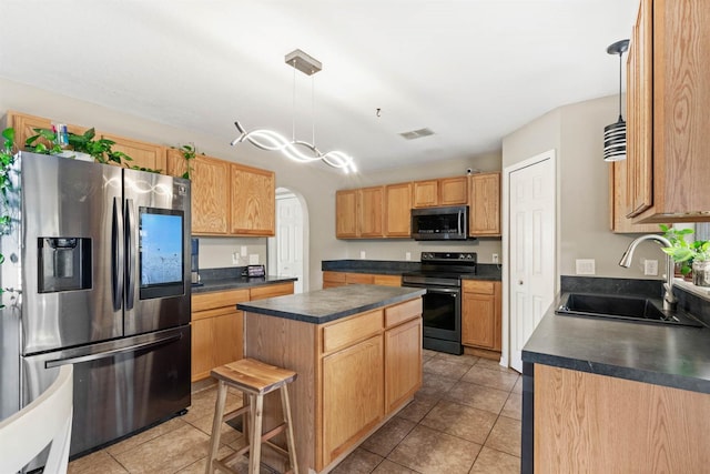 kitchen with sink, a kitchen island, pendant lighting, and appliances with stainless steel finishes