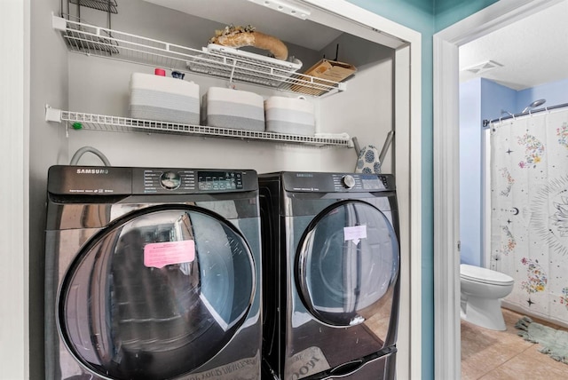 laundry area with tile patterned floors and washer and clothes dryer