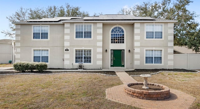 view of front of home with a front yard and solar panels