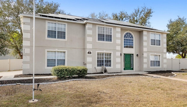 view of front facade featuring a front lawn and solar panels