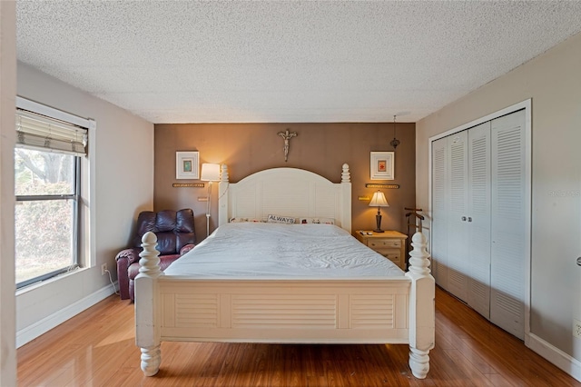 bedroom featuring hardwood / wood-style floors, a textured ceiling, and a closet