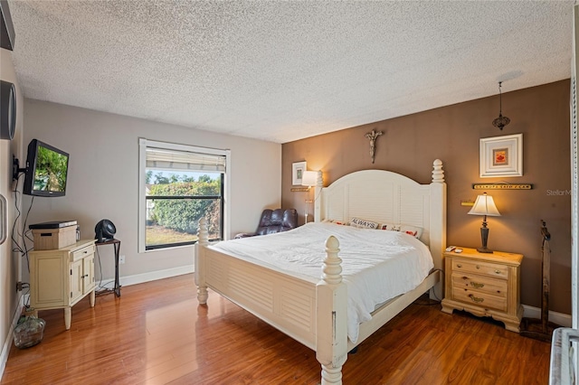 bedroom with hardwood / wood-style flooring and a textured ceiling