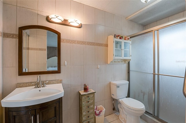 bathroom featuring vanity, an enclosed shower, tile walls, and toilet