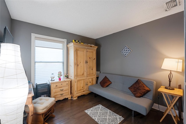 sitting room featuring dark hardwood / wood-style flooring and a textured ceiling