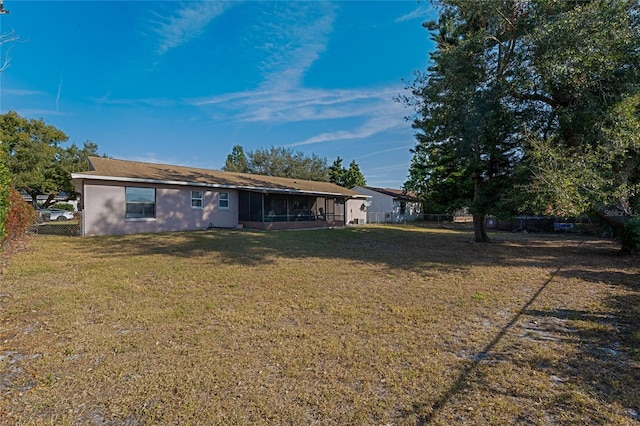 back of house featuring a yard and a sunroom